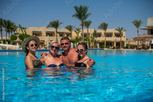 Real people concept, beautiful family, two teenage girls, mother and father swimming and having fun in pool in vacation. happiness and nice body for enjoyed people live an lifestyle as vacation