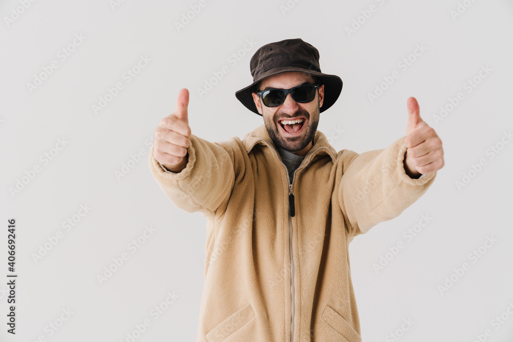 Excited handsome guy in sunglasses smiling showing thumbs up Excited handsome guy in sunglasses smiling showing thumbs up