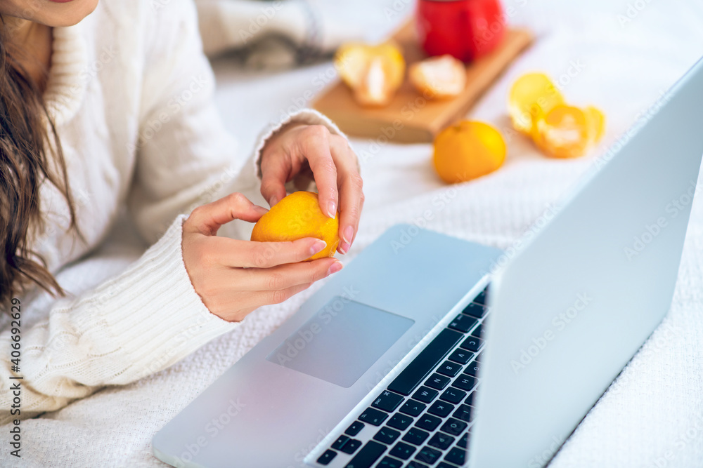 Close up picture of womans hands peeling a tangerine