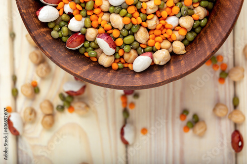 Bowl with different raw legumes on table close up, top view, copy space. Vegan protein source
