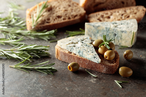 Blue cheese with green olives, rosemary, and bread.