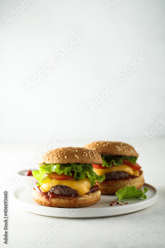 Traditional homemade cheeseburgers on a white plate