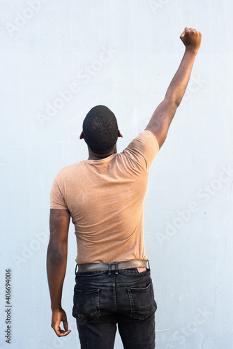 back of young black man with arm raised and fist pump photo