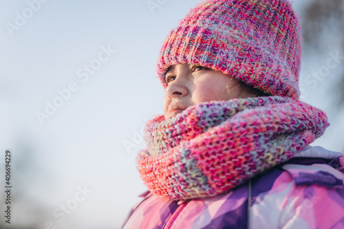 Little happy cheerful girl playing outdoors in winter snow park