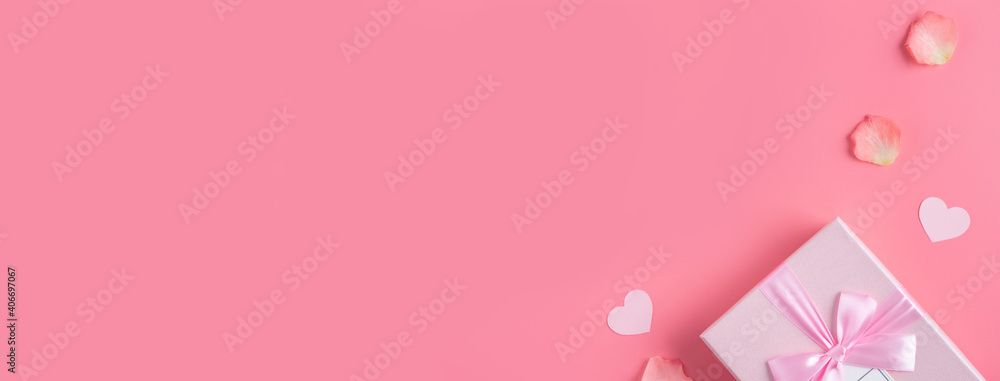 Valentine's Day design concept background with pink petals and gift box.