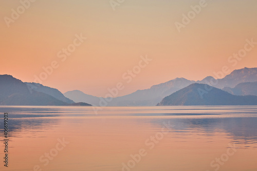 Mountain reflected sunrise in calm sea