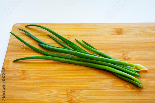 Fresh green onions on a cutting board. Drops of water on a fresh cut green onion.