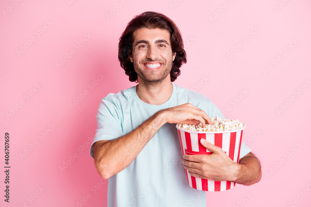 Portrait of optimistic guy eating pop corn wear blue outfit isolated on pink color background Portrait of optimistic guy eating pop corn wear blue outfit isolated on pink color background