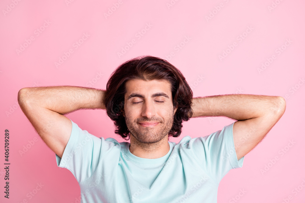Photo of handsome person hands behind head closed eyes wear light blue isolated on pink color background Photo of handsome person hands behind head closed eyes wear light blue isolated on pink color background
