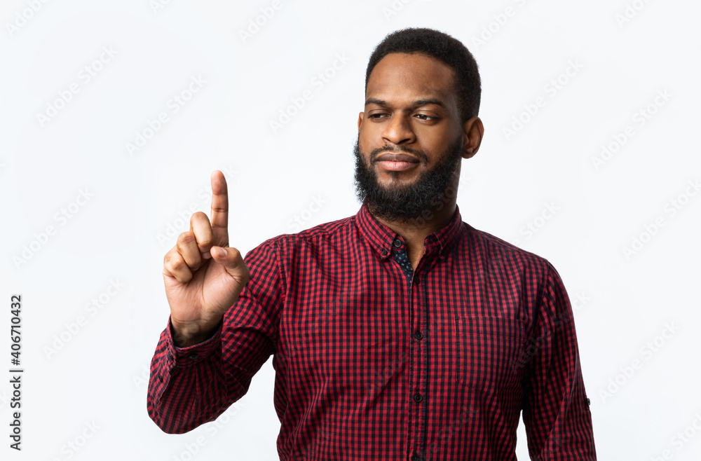 African Man Looking At Finger Holding Invisible Object, Studio Shot African Man Looking At Finger Holding Invisible Object, Studio Shot