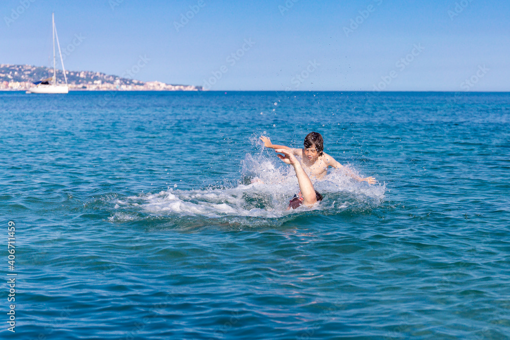 A man with his son swimming and playing in the sea.  A father throws a boy over the water. Family having fun in water