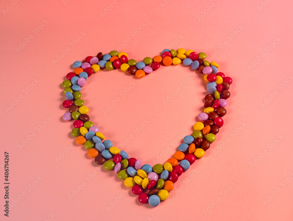 
heart created with sweets on pink background