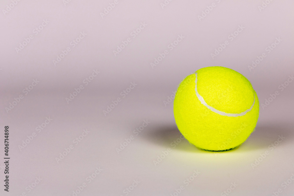 Yellow tennis ball on a light background. Close-up.