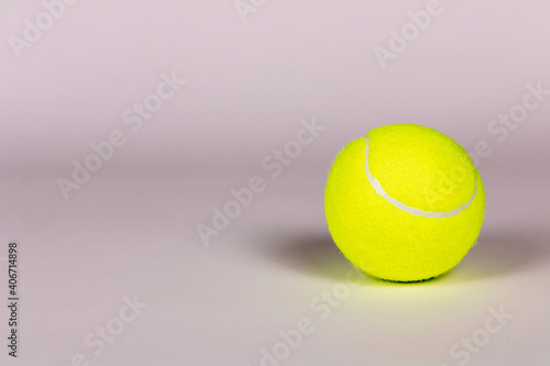 Yellow tennis ball on a light background. Close-up. © Aliaksandr