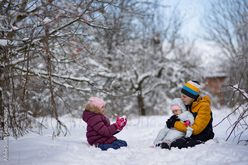 Three children on a walk in winter, a teenager