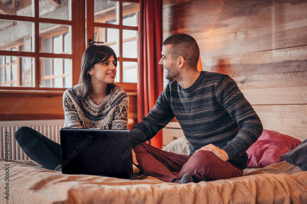 Man and woman at home surfing the net in bed. Couple caucasian lover smiling showing very happy gesture while enjoy using laptop computer together on bed Man and woman at home surfing the net in bed. Couple caucasian lover smiling showing very happy gesture while enjoy using laptop computer together on bed