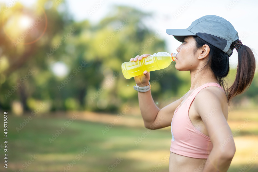 young fitness woman drinking energy water during stretching muscle in the park outdoor, asian athlete running and exercise in morning. Sport and wellness concept young fitness woman drinking energy water during stretching muscle in the park outdoor, asian athlete running and exercise in morning. Sport and wellness concept