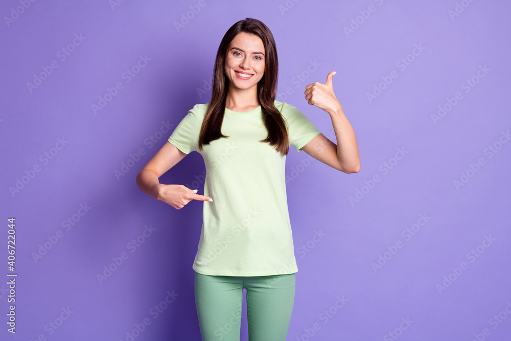 Photo portrait of young girl pointing with finger on belly showing like sign thumb-up smiling isolated on vivid purple color background Photo portrait of young girl pointing with finger on belly showing like sign thumb-up smiling isolated on vivid purple color background