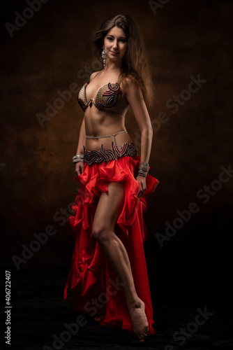 Oriental dancer with a saber. Belly dance. The brunette. Red.