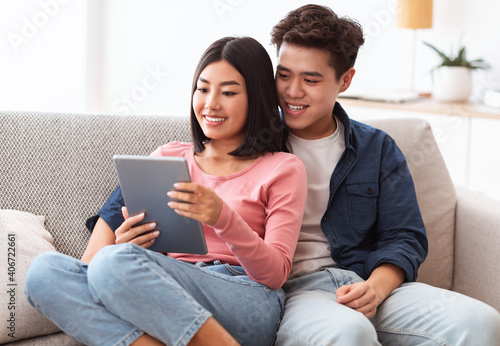 Chinese Boyfriend And Girlfriend With Tablet Watching Movie At Home
