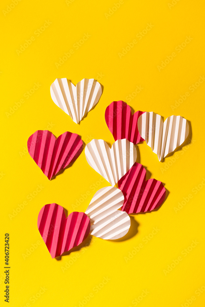 Fototapeta premium Valentine's day flat lay with copy space. Pink and white hearts on the yellow background. Image for greeting cards. Valentine's day concept