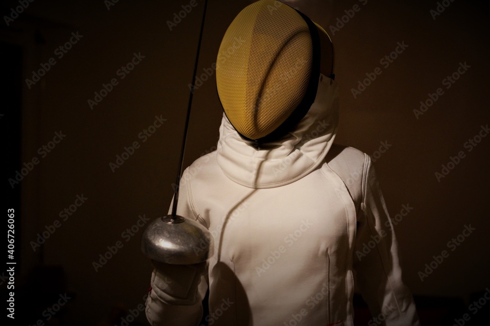 Person in swordsmans costume with a sword. Epee in the shade. Person in swordsmans costume with a sword. Epee in the shade.
