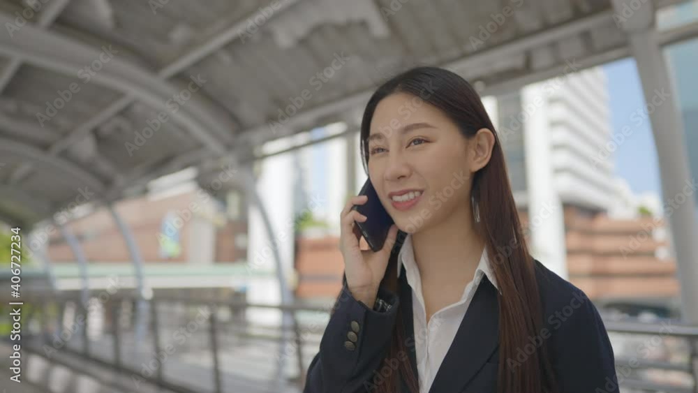 Adult asian businesswoman calling on phone outdoor in the urban city Adult asian businesswoman calling on phone outdoor in the urban city