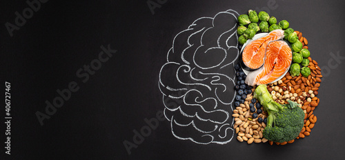 Chalk hand drawn brain picture with assorted food, food for brain health and good memory: fresh salmon, vegetables, nuts, berries on black background. Foods to boost brain power, top view, copy space
