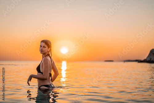 Young beautiful woman having fun in water at beach. Summer photo of young beautiful girl in sea swimming and having fun. Female on beach enjoying sea vacation traveling
