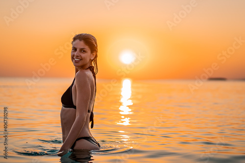 Young beautiful woman having fun in water at beach. Summer photo of young beautiful girl in sea swimming and having fun. Female on beach enjoying sea vacation traveling © Vladimir Borovic