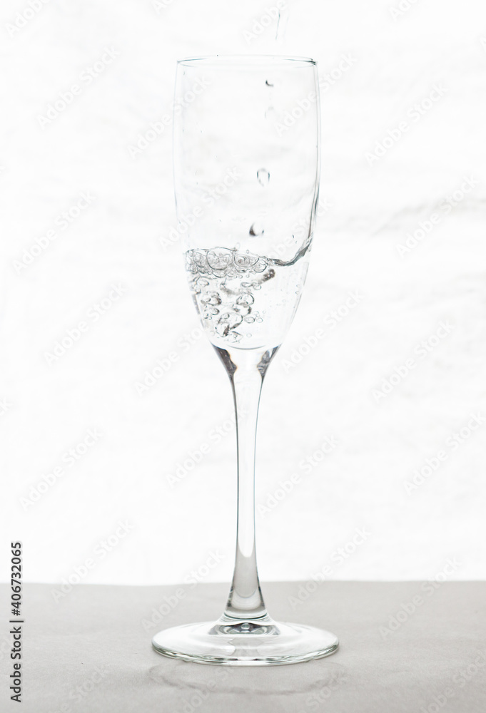 Obraz premium Filling up the champagne glass water isolated on a white background