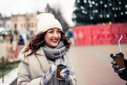 Young lovely couple bride groom newlyweds standing street drink hot tea beverage coffee chocolate, spending time together, smiling joke. New Year Christmas decorations, Valentines Day concept.  © Volodymyr