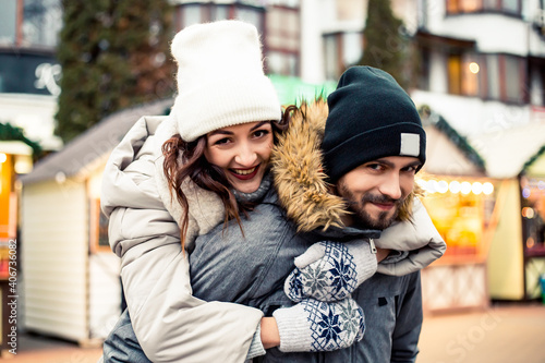 Young lovely couple bride groom newlyweds standing street kissing hugging, spending time together, smiling happy joke. New Year Christmas decorations, Valentines Day concept. © Volodymyr