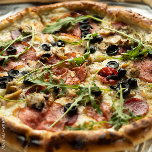 Close-up of pizza with olives, salami and cheese in a box. Delivery of orders from an Italian pizzeria.