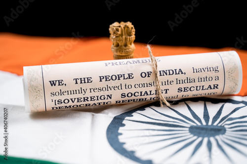 Indian constitution or Bharatiya Savidhana preamble with we the people of India writings paper placed on Indian flag - Concept of Freedom, Nationality and patriotism.