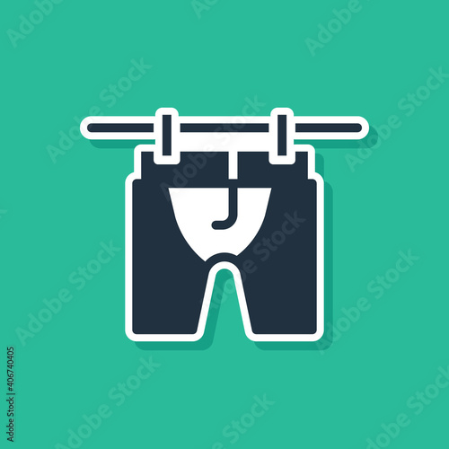 Blue Drying clothes icon isolated on green background. Clean shirt. Wash clothes on a rope with clothespins. Clothing care and tidiness. Vector.