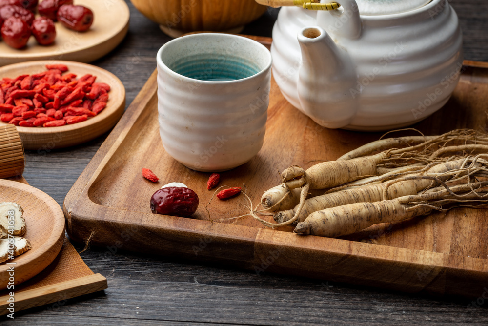Ginseng and tea cup are on the table Ginseng and tea cup are on the table