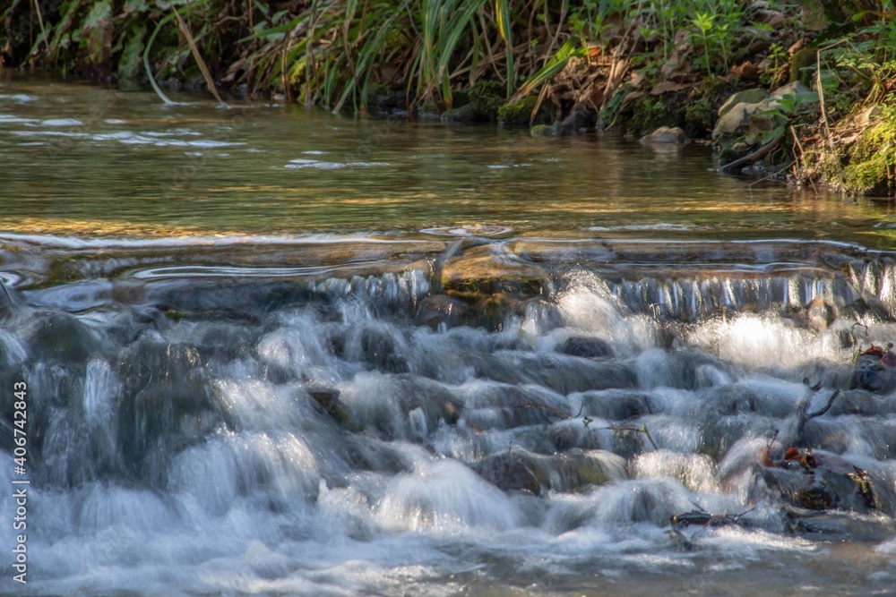 Obraz premium movement of water flowing over stones in the river