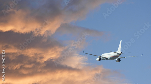 Zoom photo of airplane taking off at beautiful sunset with golden colours