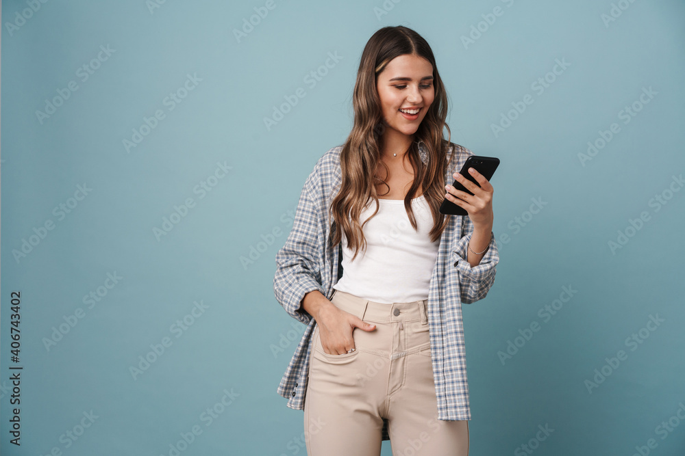 Happy beautiful girl smiling while using mobile phone Happy beautiful girl smiling while using mobile phone