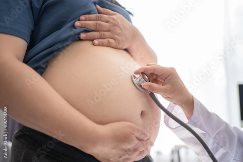 Asian doctor examining pregnant woman in hospital