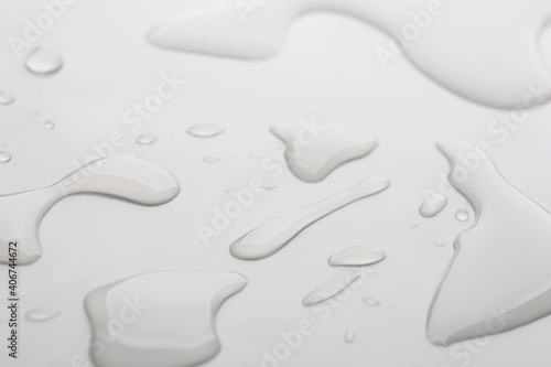 Drops of spilled water on grey background, closeup