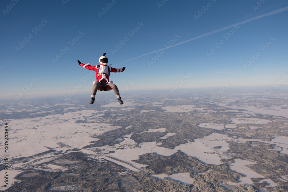 Skydiving. A girl is flying in the winter sky.