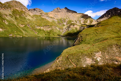Fototapeta Naklejka Na Ścianę i Meble -  Fanealm und Wilder See in Suedtirol, Italy, Alpine pastures with a deep blue lake, green meadows and a blue sky with fleecy clouds, in summer