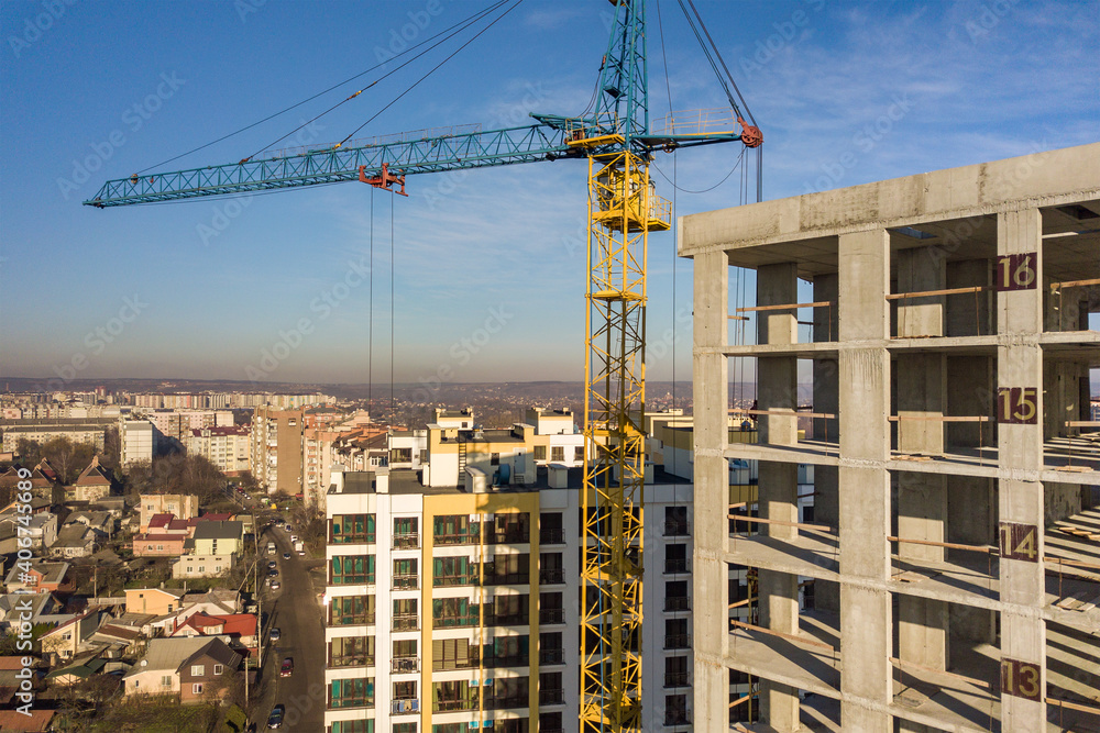 Aerial view of concrete frame of tall apartment building under construction in a city.