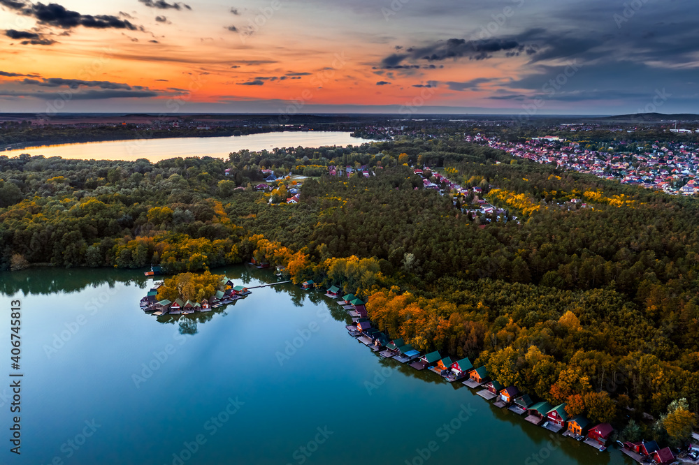 Tata, Hungary - Aerial drone view from high above the beautiful Lake Derito (Derito-to) in October with small fishing island. Old Lake (Oreg-to), colorful sunset and the city of Tata at background