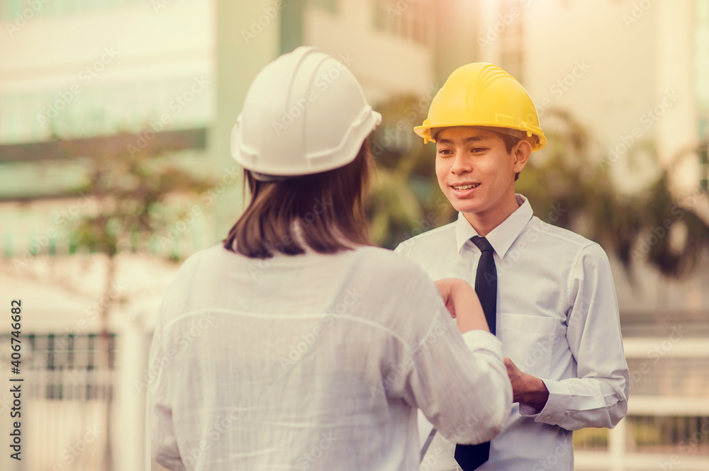 Two Asian businesspeople talking and meeting record on clipboard about building civil project Two Asian businesspeople talking and meeting record on clipboard about building civil project