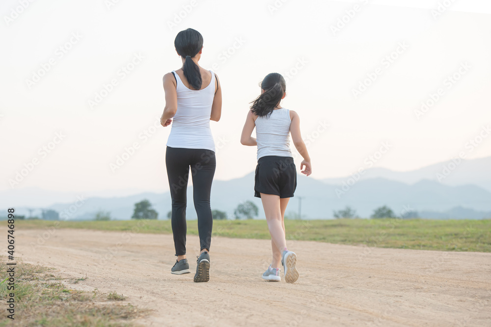 two female runners jogging outdoors in forest in autumn nature..running sporty mother and daughter. woman and child jogging in a park. outdoor sports and fitness family. two female runners jogging outdoors in forest in autumn nature..running sporty mother and daughter. woman and child jogging in a park. outdoor sports and fitness family.