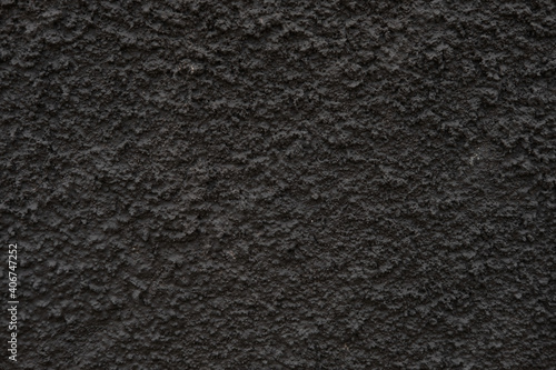 The texture of the black textured wall. Dark wall for background.