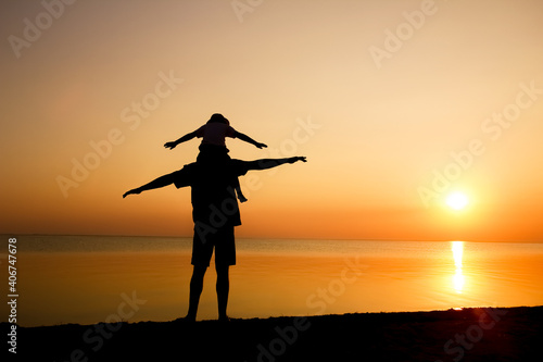 A Happy parent with child by the sea play on nature silhouette travel